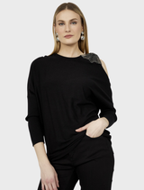Black knit top displayed on a hanger, featuring a simple design and soft texture suitable for casual wear.