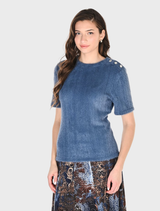 A model showcases a blue denim shirt paired with a stylish skirt, highlighting a casual yet fashionable look.