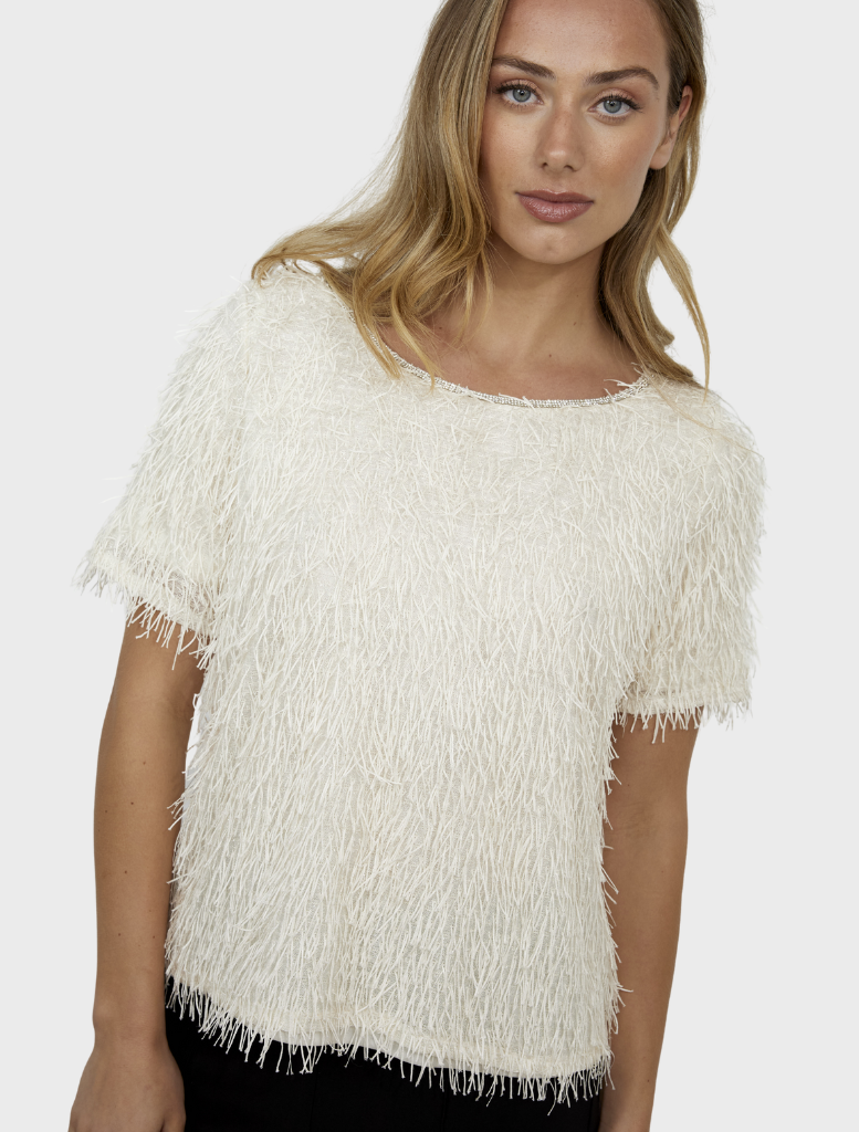 A vanilla-colored knit top shown on a mannequin, highlighting its cozy fabric and relaxed fit for casual outfits.
