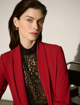 Fitted black lace top featuring a mock neck, cap sleeves with scalloped edges, and an invisible back zipper for closure.