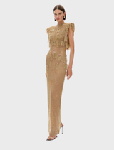 Elegant gold Lani gown displayed on a mannequin, showcasing its flowing fabric and intricate design details.
