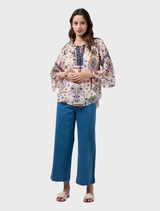 Floaty blouse with flared sleeves, shirred shoulders, and contrast details for a flattering fit.