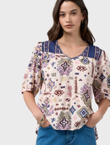 Printed short-sleeve top featuring a contrast yoke and neck bind, with tucks at the yoke seams and sleeve head for detail.
