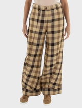 A woman models brown plaid trousers, showcasing a stylish and comfortable outfit suitable for casual wear