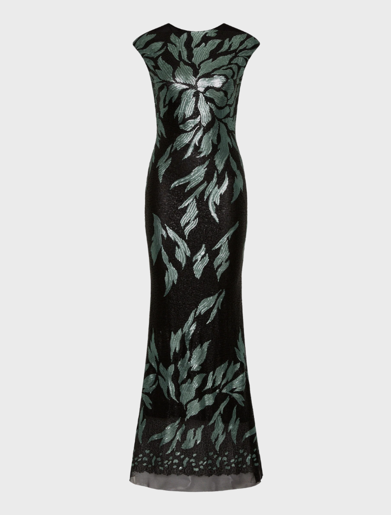 A model displays a fashionable black and green dress, blending elegance with modern design elements.