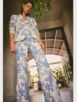 A woman wearing a blue and white floral suit, featuring the Leandro Contrast Lace Linen Viscose Stretch Pant in Azure Mosaic.