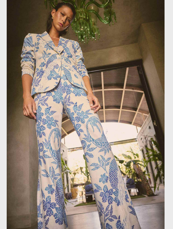 A woman wearing a blue and white floral suit, featuring the Leandro Contrast Lace Linen Viscose Stretch Pant in Azure Mosaic.