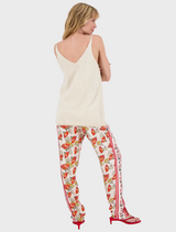  A woman is seen wearing a white tank top and red pants, presenting a bright and casual fashion choice.