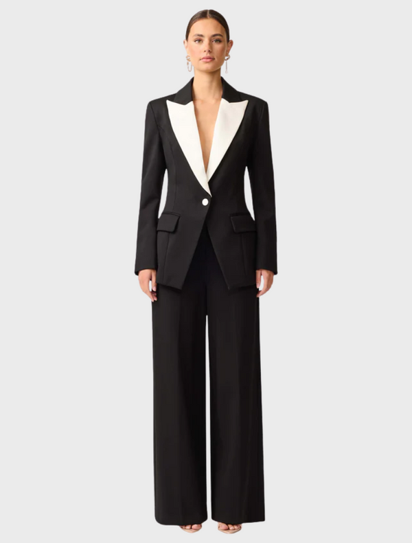 A black and white wool suit displayed on a hanger, showcasing its tailored design and fabric texture.