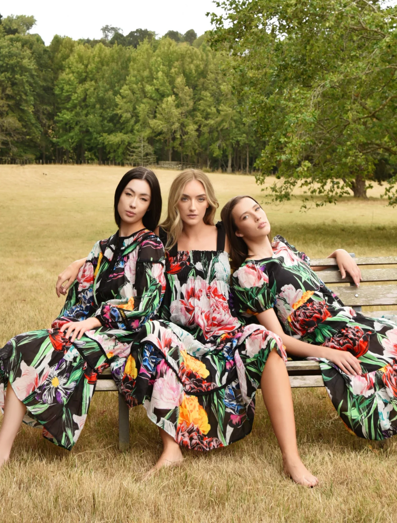 A women is seen in a floral print dress and Giving he pose for the Camera
