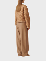 A collection of light brown coats arranged neatly, highlighting different designs and fabrics in a clothing store.