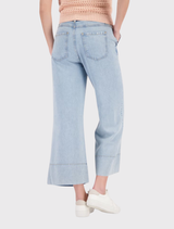 Light denim ⅞ wide-leg jeans, 100% lyocell, with side pockets and a wide hem, modeled by a person 1.80 m tall.