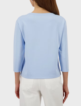 Light sky blue jersey with a round neck and a minimalist emblem design.