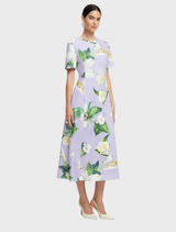 A dress designed with a bright floral pattern, displaying an assortment of flowers in various colors on a soft fabric.
