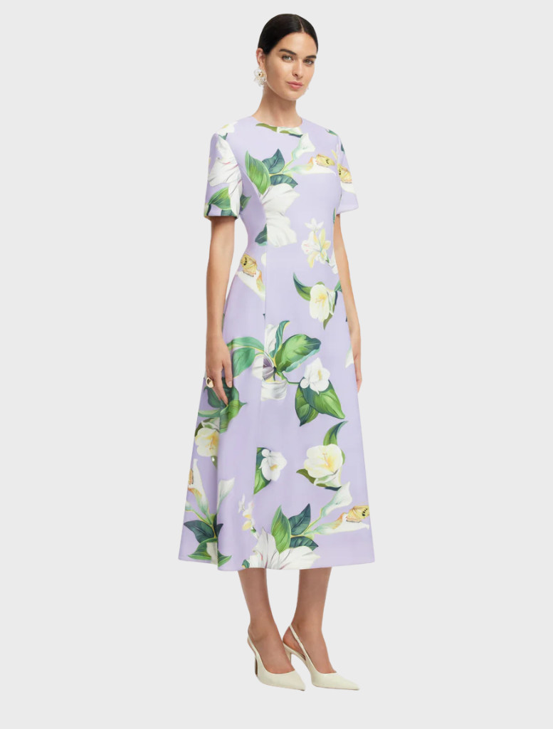 A dress designed with a bright floral pattern, displaying an assortment of flowers in various colors on a soft fabric.
