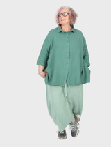 A pair of lime green linen trousers, emphasizing their casual style and breathable material.