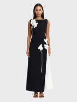 Black and ivory Limisi maxi dress with pleated side skirt and flower appliqués, ideal for formal occasions and evening events.