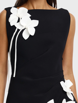 Stylish black and ivory maxi dress showcasing a pleated side skirt and floral appliqués, designed for confident evening wear.