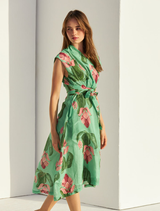 Elegant green linen dress draped on a hanger, highlighting its soft fabric and casual silhouette against a light background.