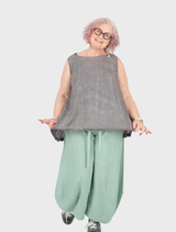 Lime linen trousers displayed on a white background, showcasing their lightweight fabric and relaxed fit.