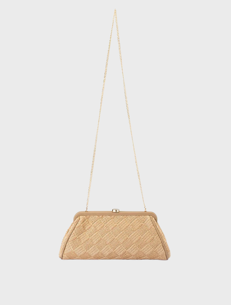 Beige woven clutch bag, labeled Lois Woven Frame Bag - Natural  hanging on a hook.