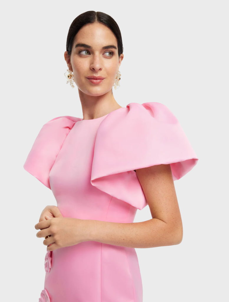 A pink dress showcasing a beautiful floral pattern, combining elegance with a touch of nature-inspired design.


