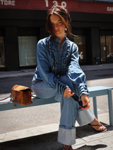 Model wearing a denim Luna blouse, demonstrating its fit and casual style.