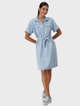 A woman dressed in a denim shirt dress with a collar, made from lyocell, exuding a relaxed and fashionable vibe.