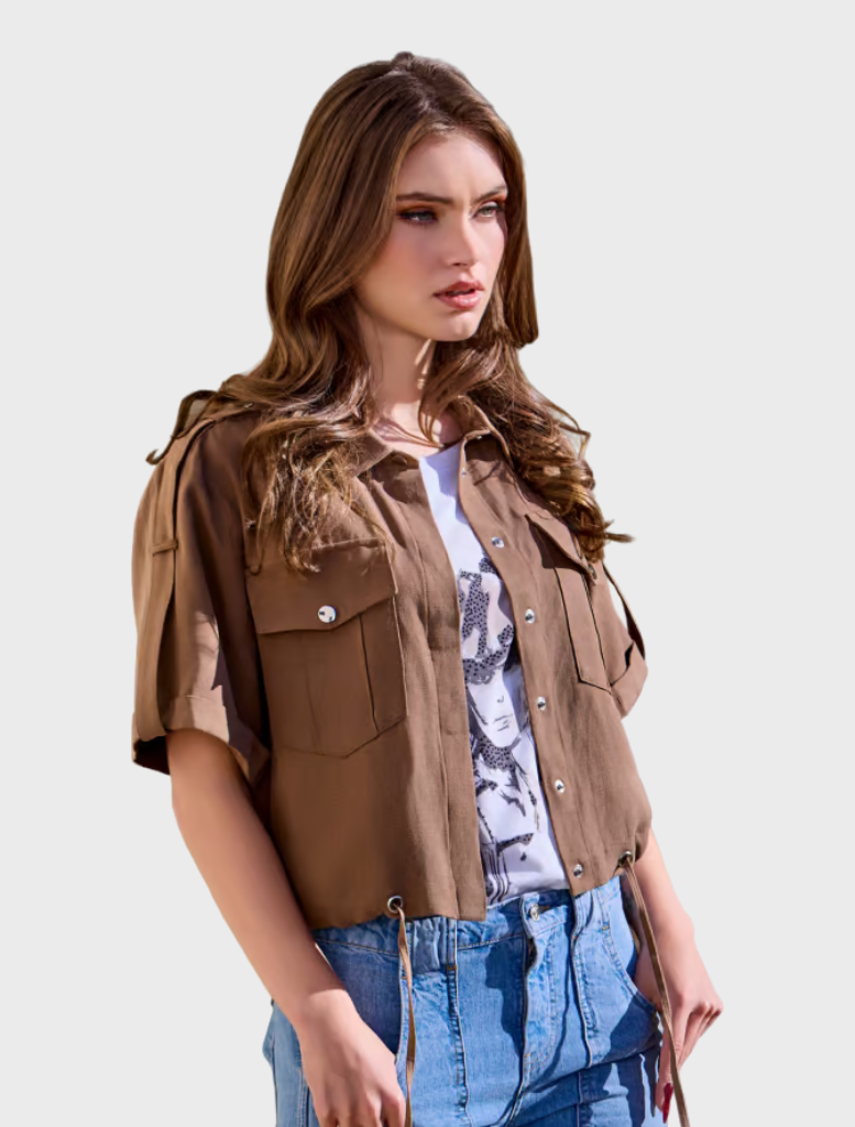 A woman dressed in a brown shirt collar jacket and jeans, exuding a relaxed fashion sense.
