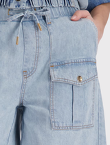 Elegant light denim shorts made of 100% lyocell, designed with an elastic waistband and practical side and flap pockets.