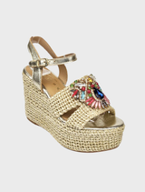 Women's gold wedge sandals adorned with a stylish floral pattern.
