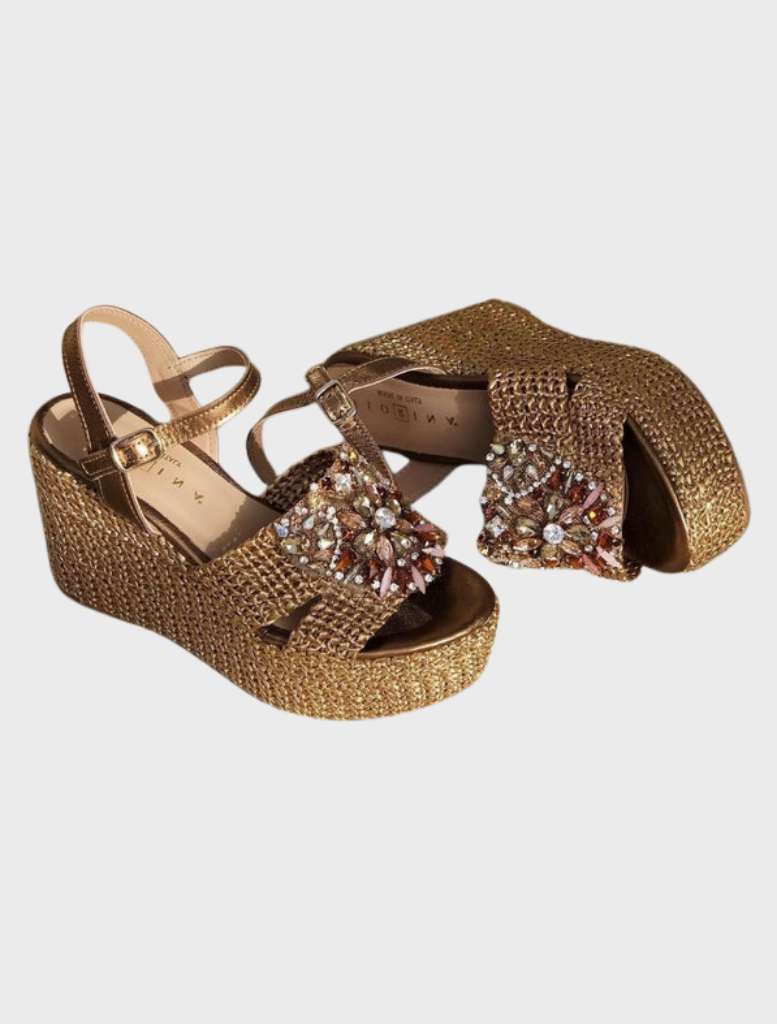 A woman in a vibrant red dress and sandals stands on steps, exuding elegance and confidence.