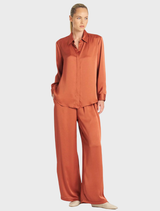 Close-up of copper Maxi Pace Pant, focusing on the fabric details and stitching for a stylish athletic look.