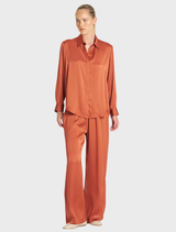 Copper Maxi Pace Pant draped elegantly, illustrating its contemporary design and comfortable fit for active wear.