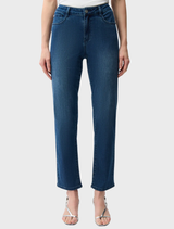 A woman dressed in slim fit stretch jeans and a shirt poses, highlighting a modern and casual fashion choice.