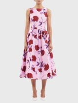 The Melora Midi Dress showcases a lilac vintage rose print, boat neckline, fitted bodice, and a graceful circular skirt with pockets.