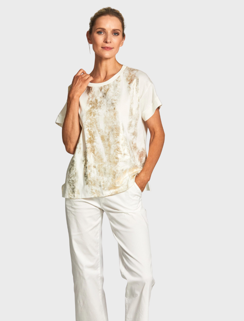 A white top made from tie-dye fabric, displaying a mix of colors in a trendy, casual style.