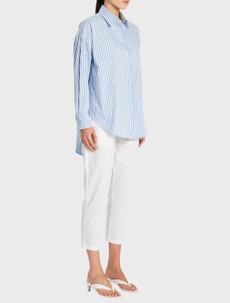 A model poses in a blue and white striped shirt, emphasizing a fashionable and relaxed appearance.