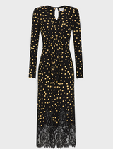 A black dress adorned with gold polka dots and finished with elegant lace trim.