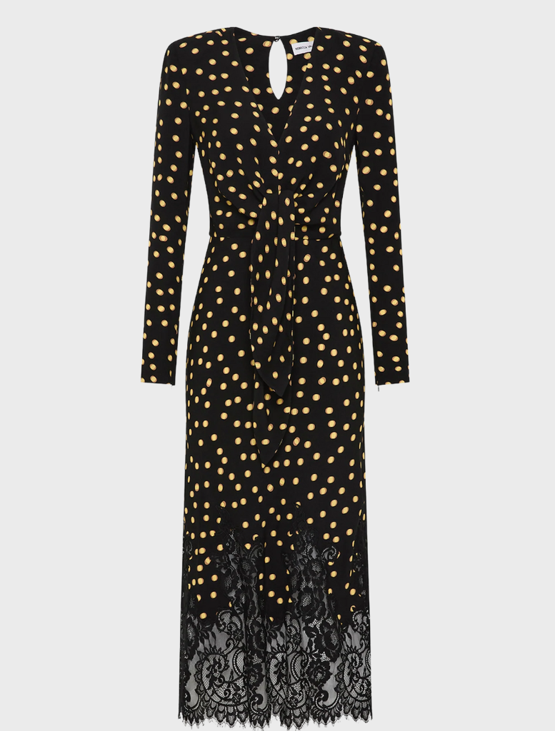 A black dress adorned with gold polka dots and finished with elegant lace trim.