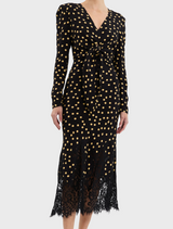 A black and gold polka dot dress, highlighted by a beautiful lace trim along the edges.