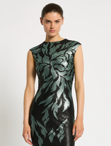 A model showcases a chic black and green dress, highlighting contemporary fashion trends.