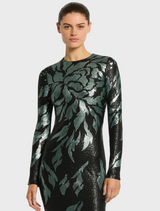 A woman models the Larissa Midi Dress in Mint Black, featuring a black base with a vibrant green leaf print.