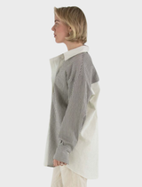 Elegant grey Mira blouse presented on a hanger, illustrating its contemporary design and quality.