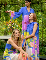 A three woman in a cobalt blue dress adorned with floral designs, embodying a modern romantic aesthetic.