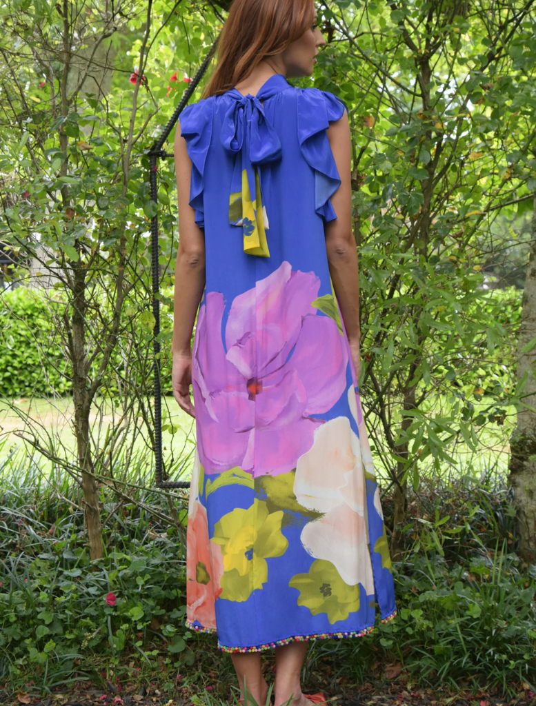 A woman wearing a cobalt floral dress, showcasing a modern romantic style with vibrant blue and floral patterns.