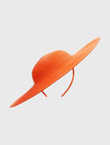 Modern orange racewear hat featuring a sculptural shape and fitted headband for comfort and effortless styling.