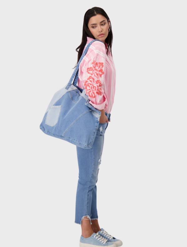 A detailed view of multiple layers of denim fabric, highlighting the rich blue color and unique textures.