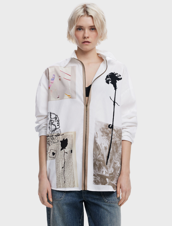 A model showcases a white shirt featuring an abstract design, highlighting modern fashion aesthetics.