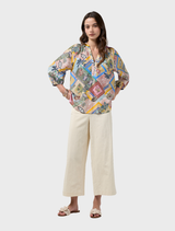 Elegant floaty blouse with V neckline, blouson sleeves gathered at elastic cuffs, adorned with custom embroidery details.